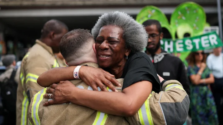 Grenfell survivors embrace firefighters at emotional anniversary march