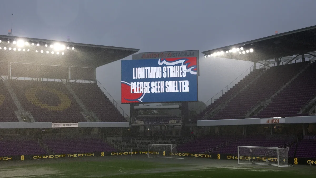 A-warning-for-lightning-strikes-appears-on-the-big-screen-as-heavy-rain-falls-prior-to-the-Internati